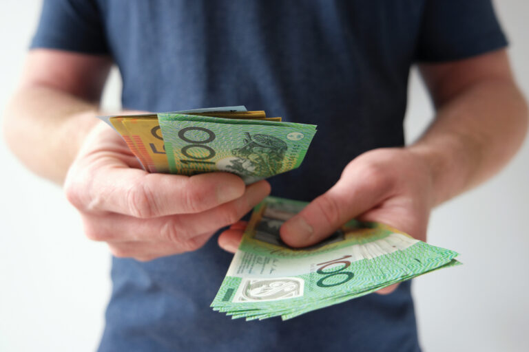 Man handling hundred and fifty Australian dollar bills.